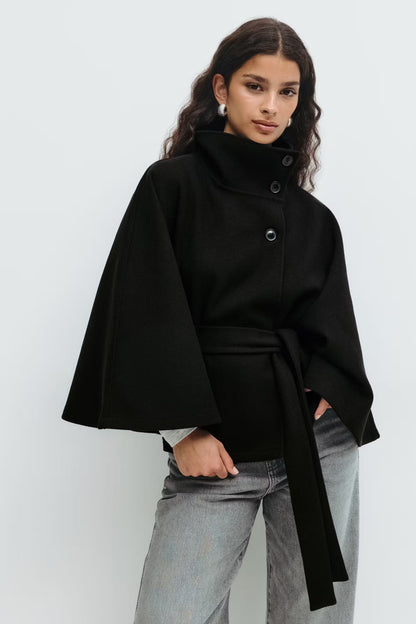 Women's funnel neck cape sleeve draped coat in black, side view