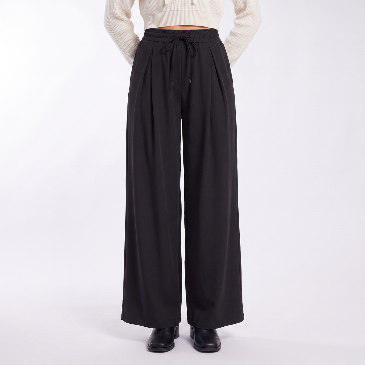 Women's pleated drawstring wide leg trousers in black, front view
